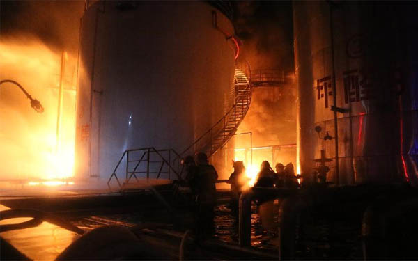 在發生火災的儲罐區,消防救援人員正在全力撲滅大火