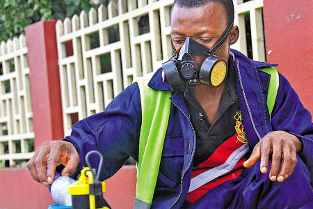 工人戴上防毒面具對化學品周轉，預防職業中毒